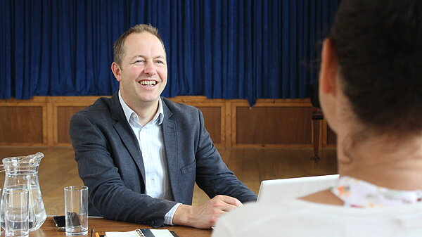 Richard Foord sat smiling at a woman across a table